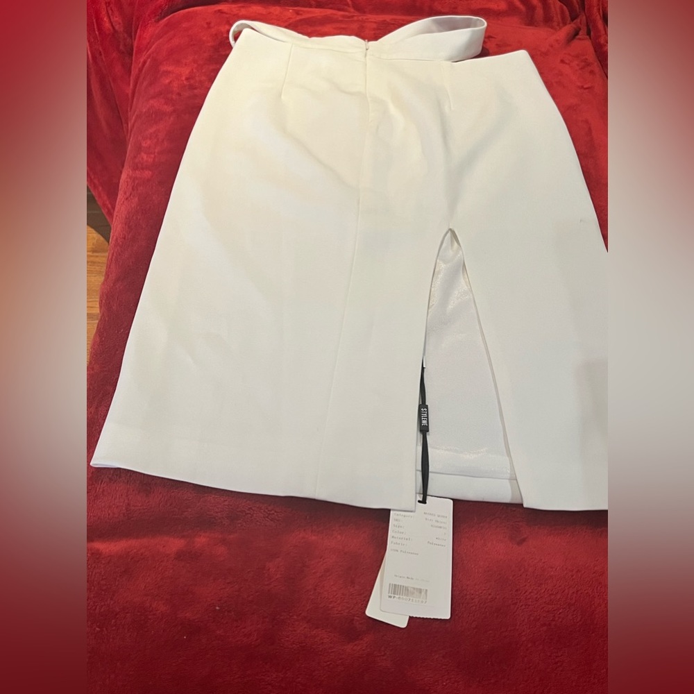 White midi skirt with slit on the side. Size is large but is more a slim fit